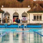 Someone swimming butterfly towards the camera in a lido