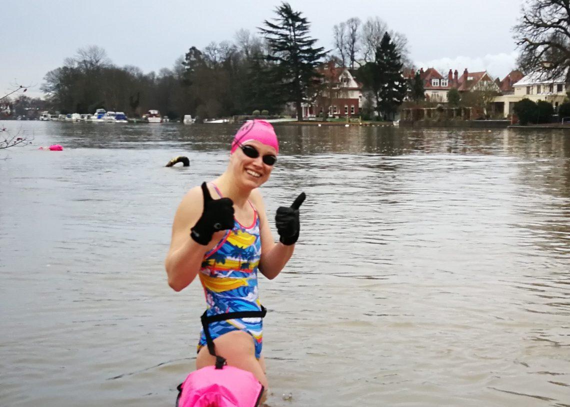 A swimmer wearing neoprene gloves, about to enter the water.