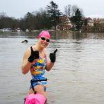 A swimmer wearing neoprene gloves, about to enter the water.