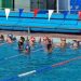Swimmers waiting to swim, in an outdoor pool.