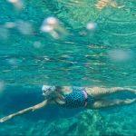 An underwater shot of a female swimmer from the side.